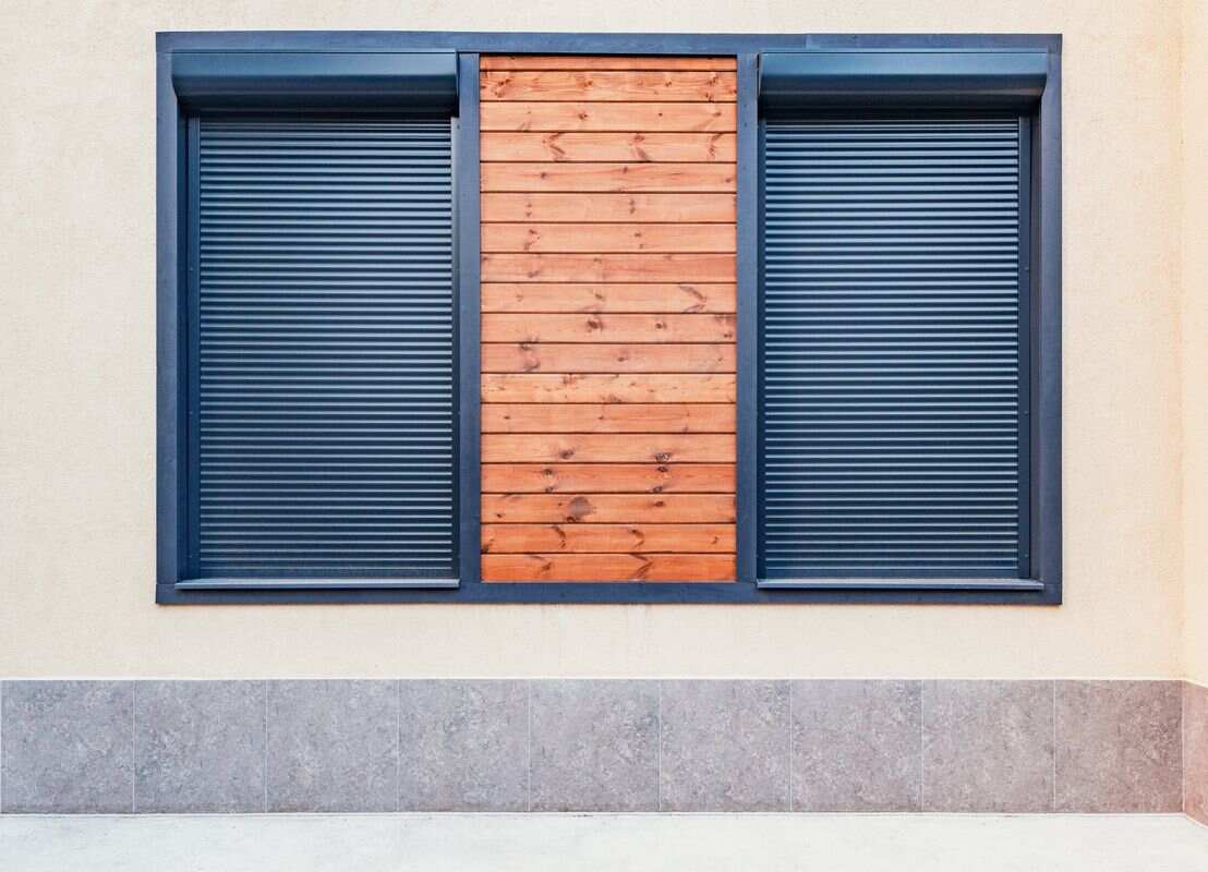 Volets roulants anthracites avec décor bois sur la façade